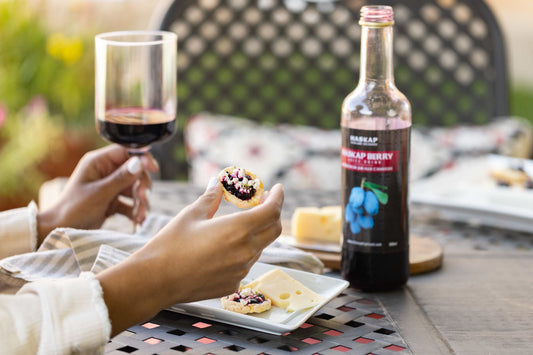 Woman drinking haskap juice and eating a canape with haskap berry jam