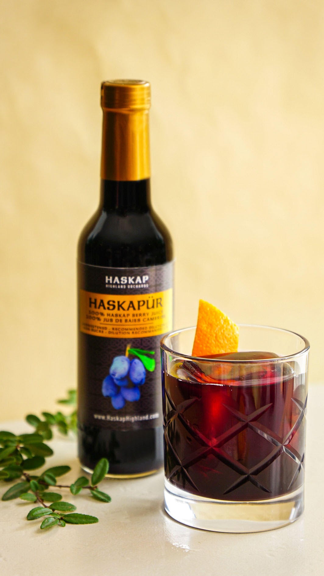 Haskap Old Fashioned mocktail in short glass with orange and Haskapur