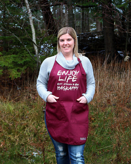 Haskap Highland Orchards apron on staff with the slogan, Enjoy Life. Eat, Drink & Be Haskappy!