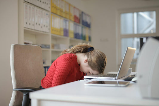 Person resting on their desk due to busy day