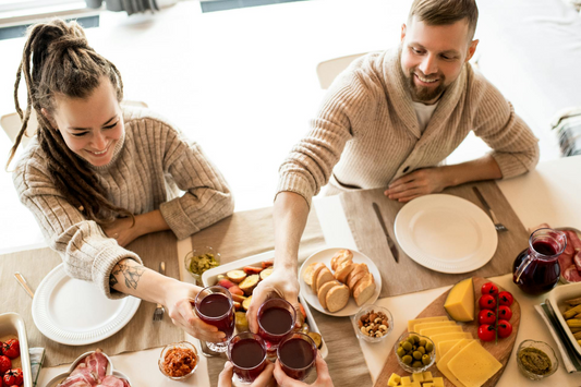 A young couple at a family lunch, clinking glasses of Haskap juice.