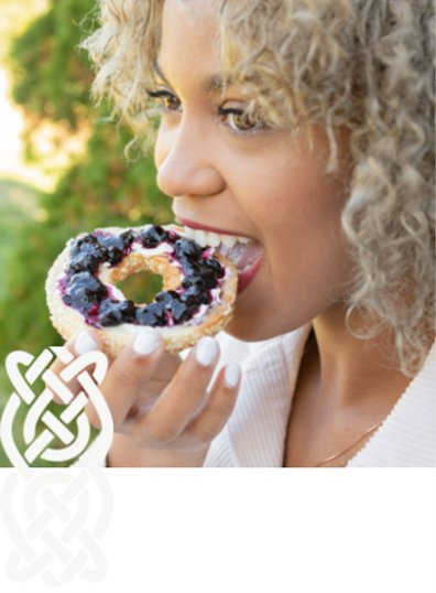 Woman eating a bagel with cream cheese and haskap berry preserve from Haskap Highland Orchards